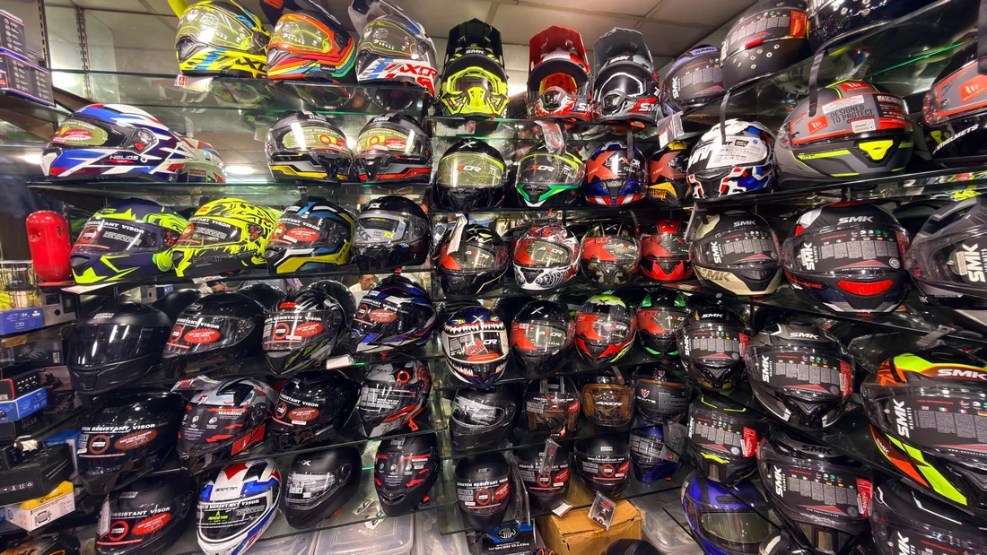 A full wall of motorcycle helmets in every colour at Speed World