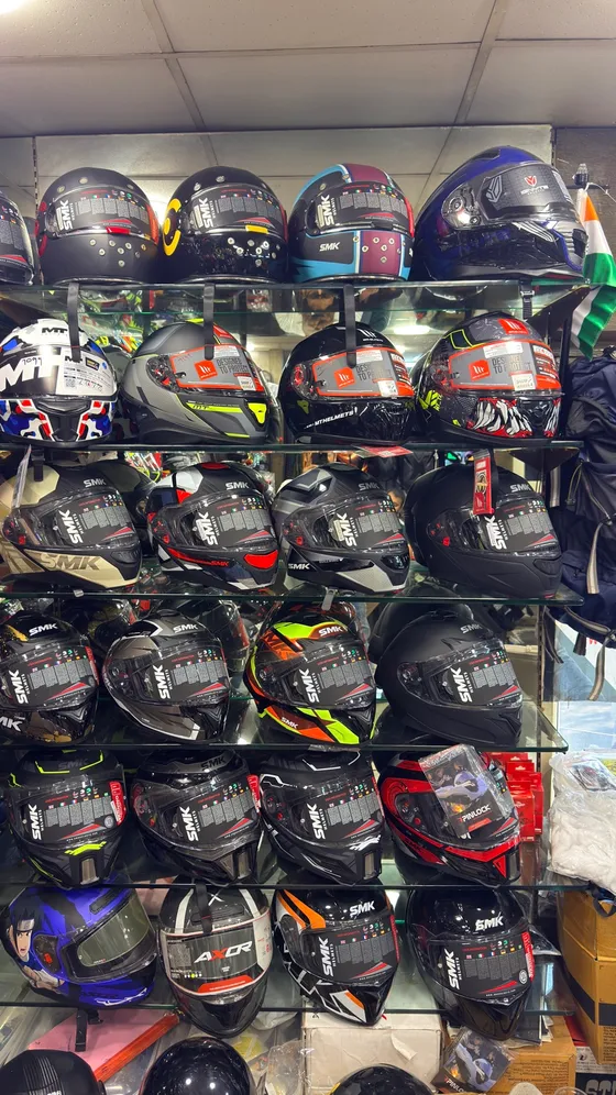 Helmets stacked across the wall — Axor, SMK and more
